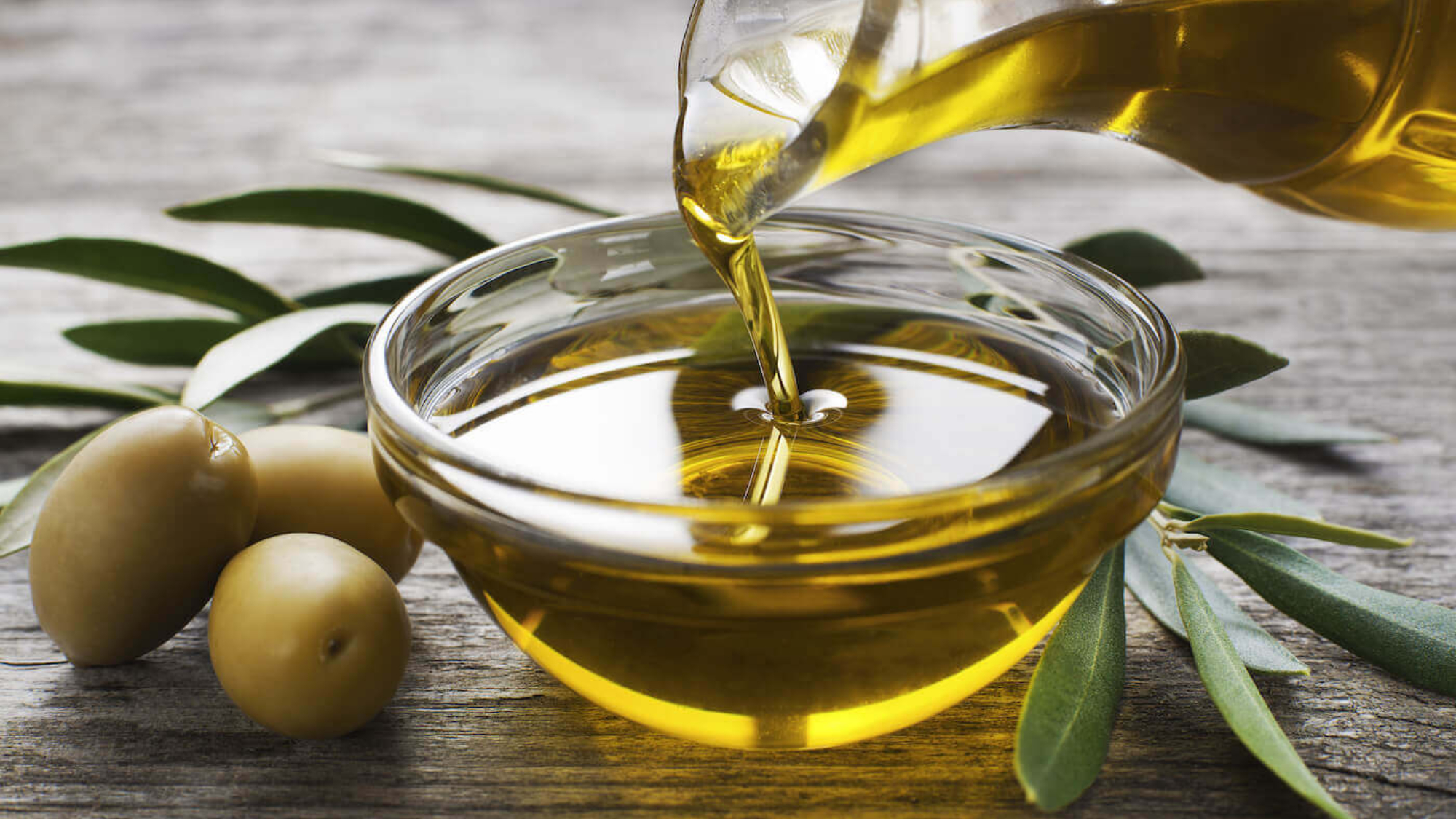 Olive-oil-being-poured-into-glass-bowl