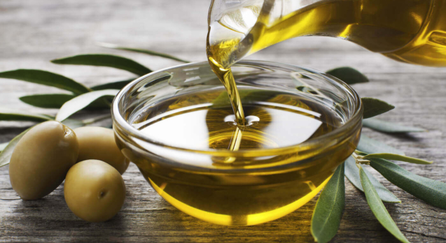 Olive-oil-being-poured-into-glass-bowl